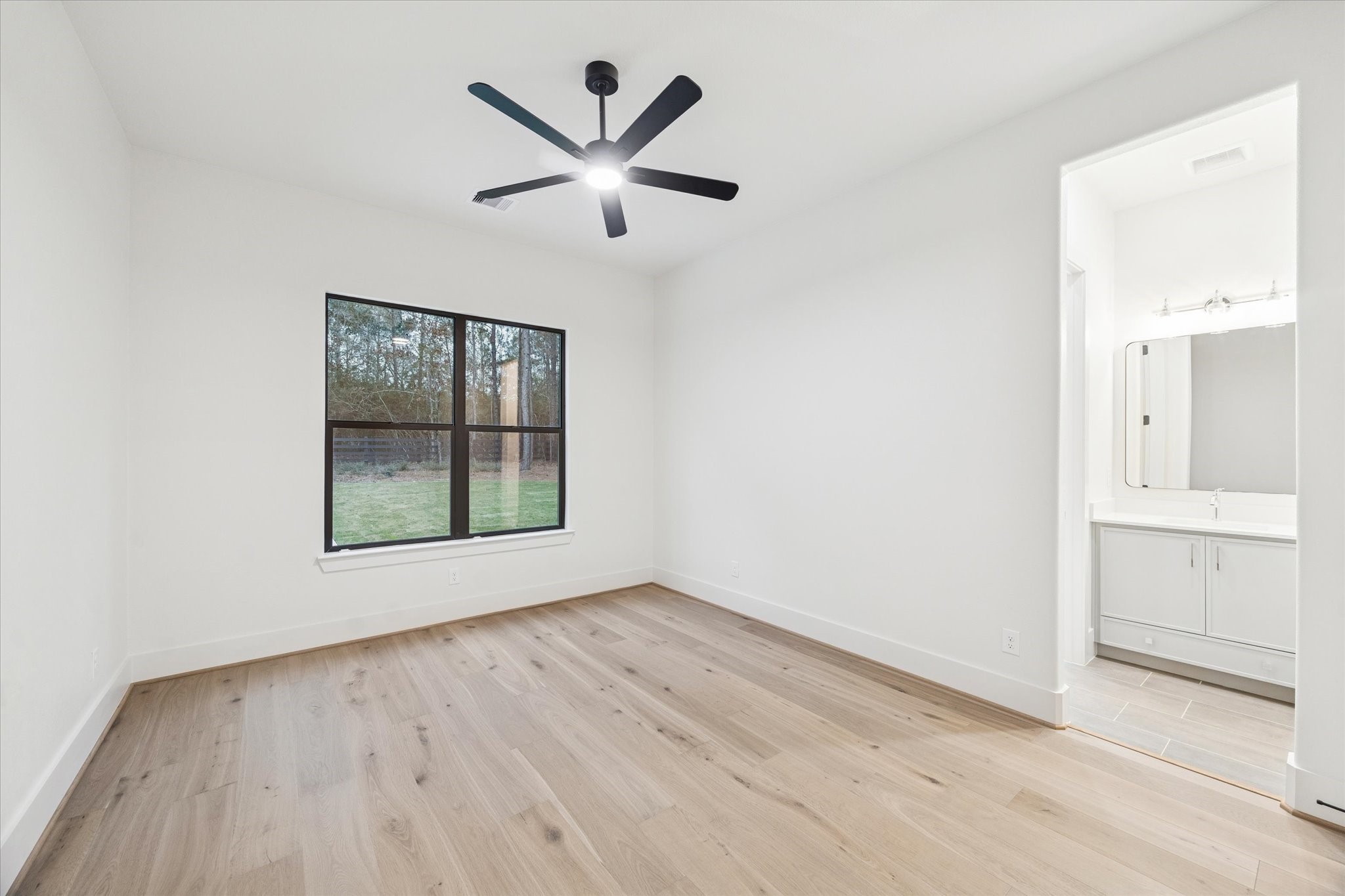 25179 Balmorhea Way Montgomery, TX 77316 - Photo 23 of 40 an empty room with wooden floor a ceiling fan and windows