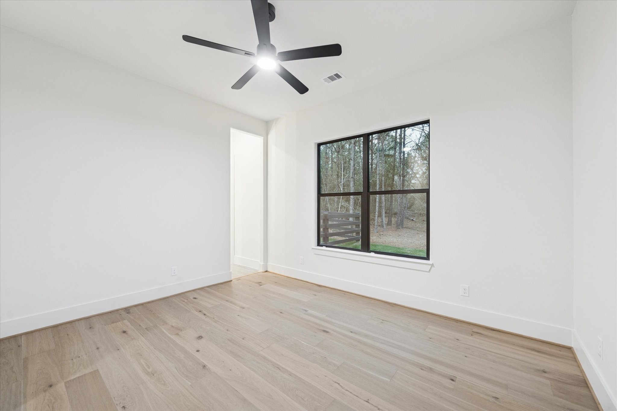 25179 Balmorhea Way Montgomery, TX 77316 - Photo 25 of 40 an empty room with wooden floor chandelier and windows