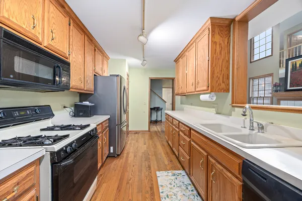 a kitchen with stainless steel appliances granite countertop a stove a sink dishwasher and a refrigerator