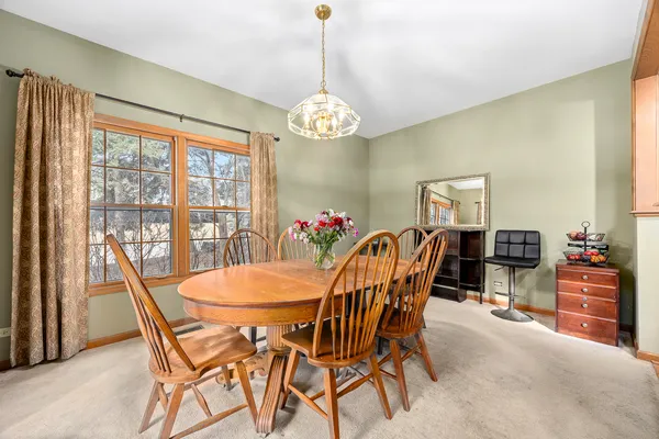 a dining room with furniture a chandelier and wooden floor