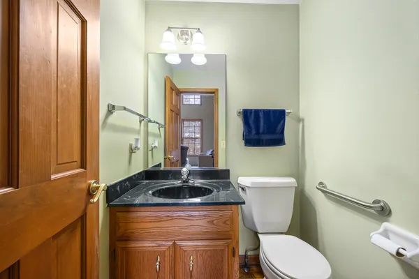 a bathroom with a granite countertop toilet sink and mirror