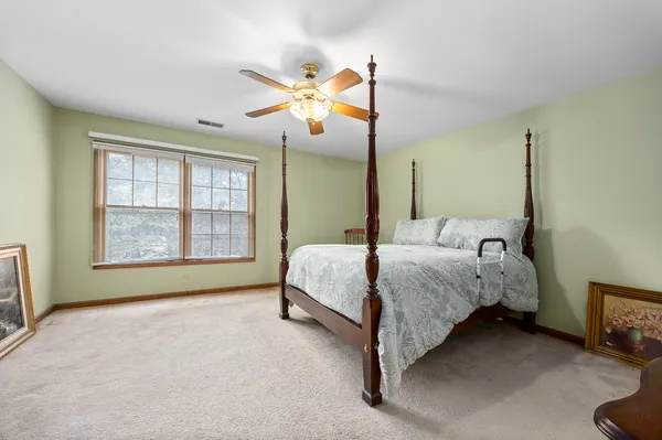 a spacious bedroom with a bed table and window
