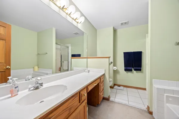 a spacious bathroom with a sink a mirror and shower
