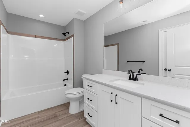 a bathroom with a sink a toilet and a large mirror