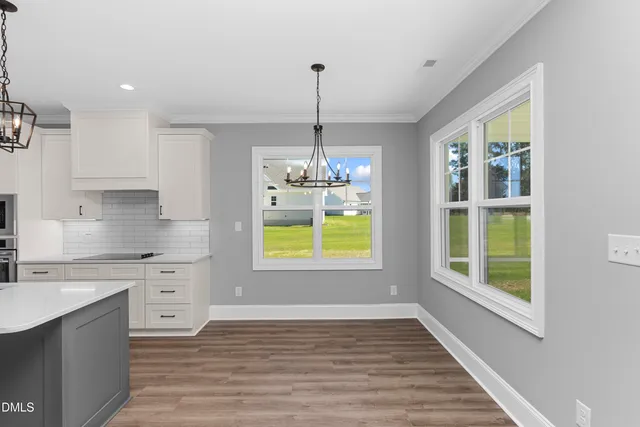 a kitchen with stainless steel appliances granite countertop a stove a sink a window and cabinets