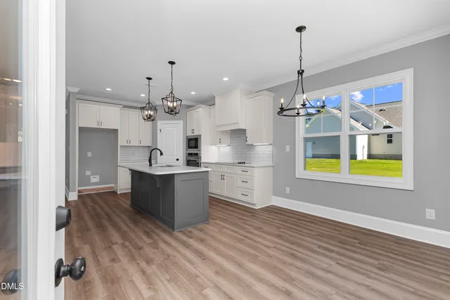 a large kitchen with stainless steel appliances granite countertop a sink dishwasher and a wooden floor