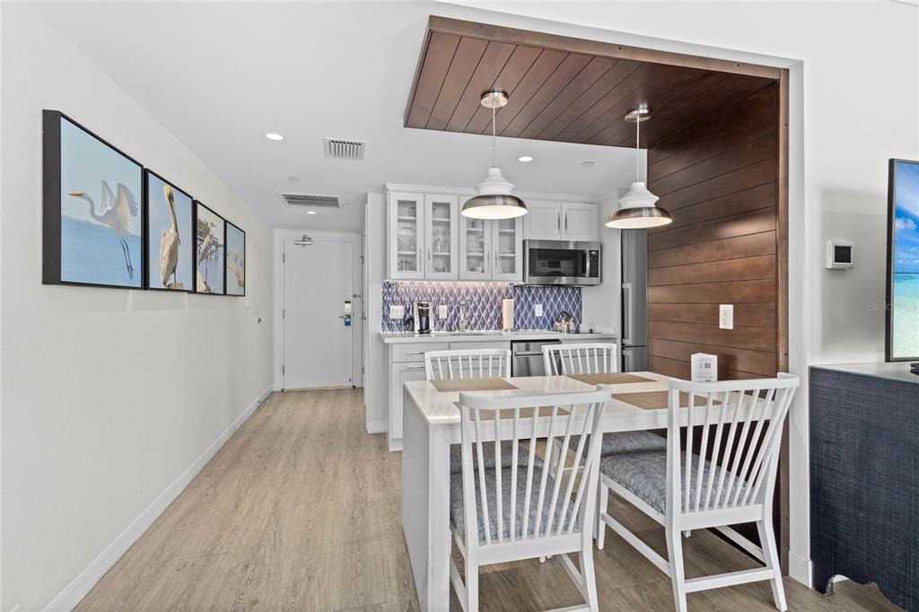 230 Sands Point Road, Unit 3205 Longboat Key, FL 34228 - Photo 13 of 38 a dining room with a wooden table and chairs