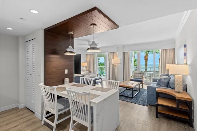 a dining room with furniture a chandelier and wooden floor