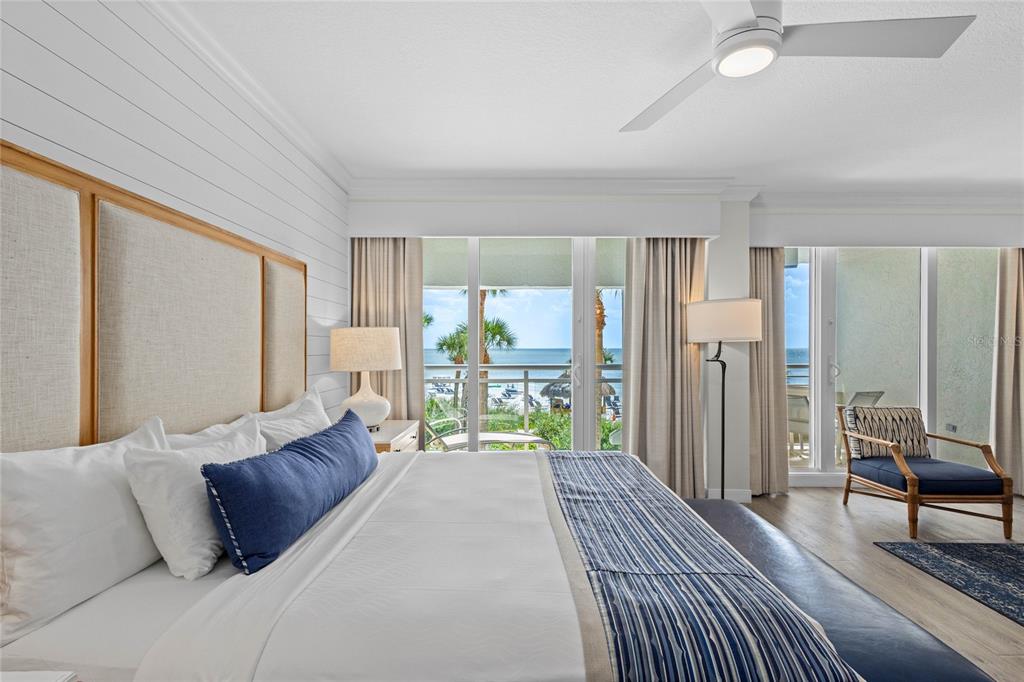 230 Sands Point Road, Unit 3205 Longboat Key, FL 34228 - Photo 6 of 38 a spacious bedroom with a bed a chandelier and large window