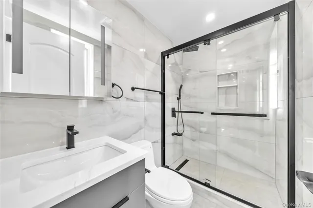 a bathroom with a sink a toilet and shower