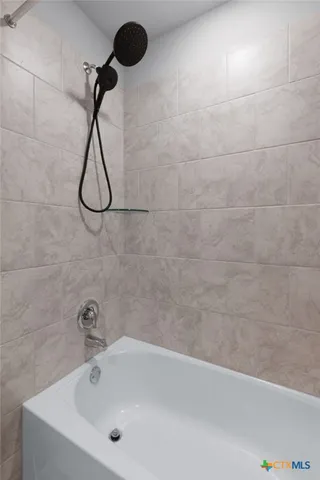 a bathroom with a bath tub with a shower