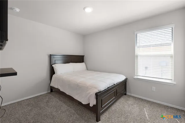 a bed sitting in a bedroom next to a window
