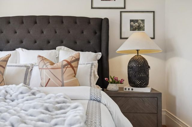 a bedroom with a large bed and large windows