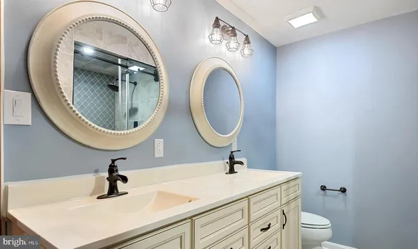 a bathroom with a sink a toilet and a mirror