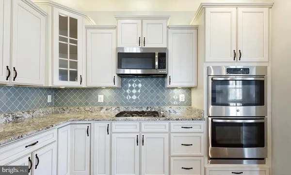 a kitchen with stainless steel appliances a stove microwave and refrigerator