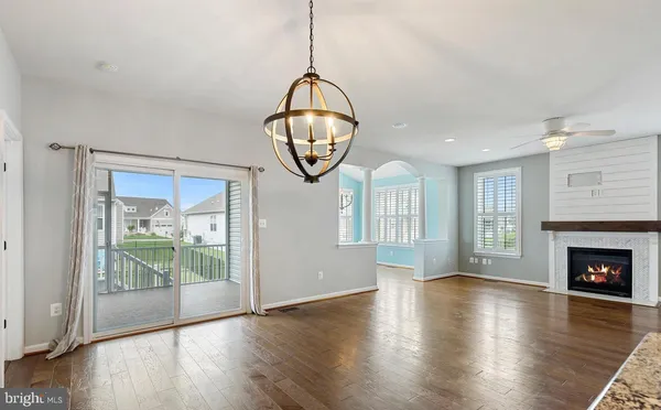an empty room with wooden floor mirror and windows