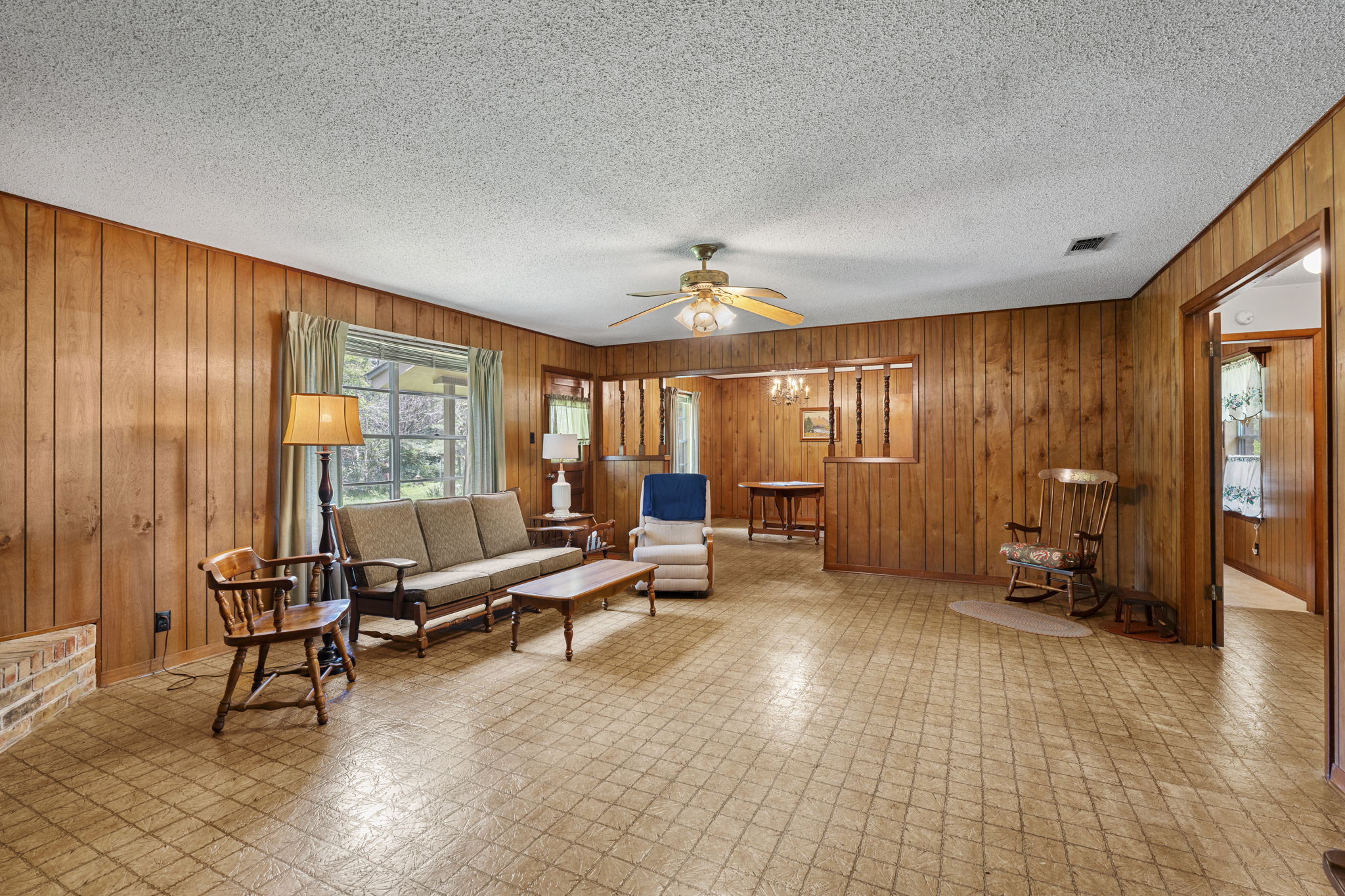 3511 Wyldwood Road Austin, TX 78739 - Photo 13 of 40 Living area featuring wooden walls, a textured ceiling, a ceiling fan, and tile patterned floors