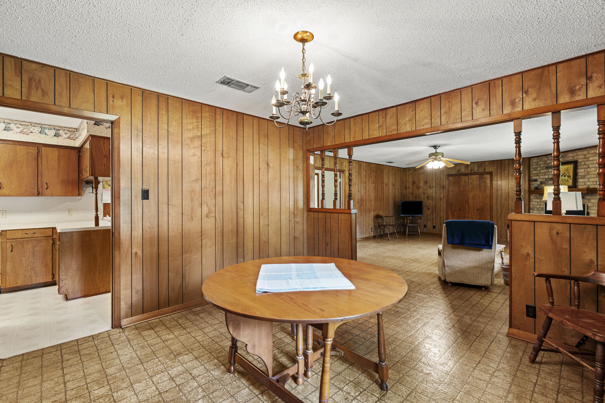 3511 Wyldwood Road Austin, TX 78739 - Photo 15 of 40 Dining area featuring light flooring, wood walls, ceiling fan, a chandelier, and a textured ceiling