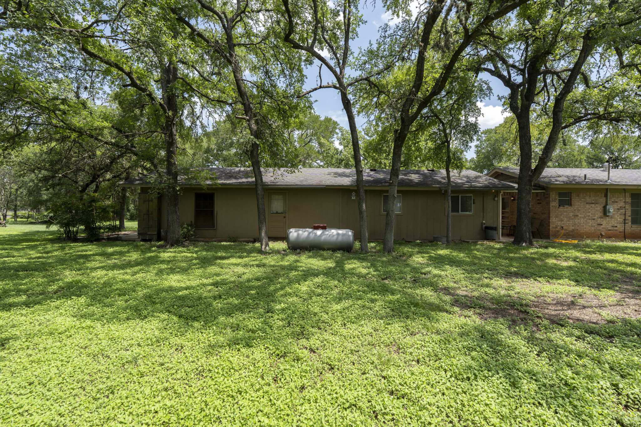 3511 Wyldwood Road Austin, TX 78739 - Photo 35 of 40 Back of house featuring a yard and roof with shingles