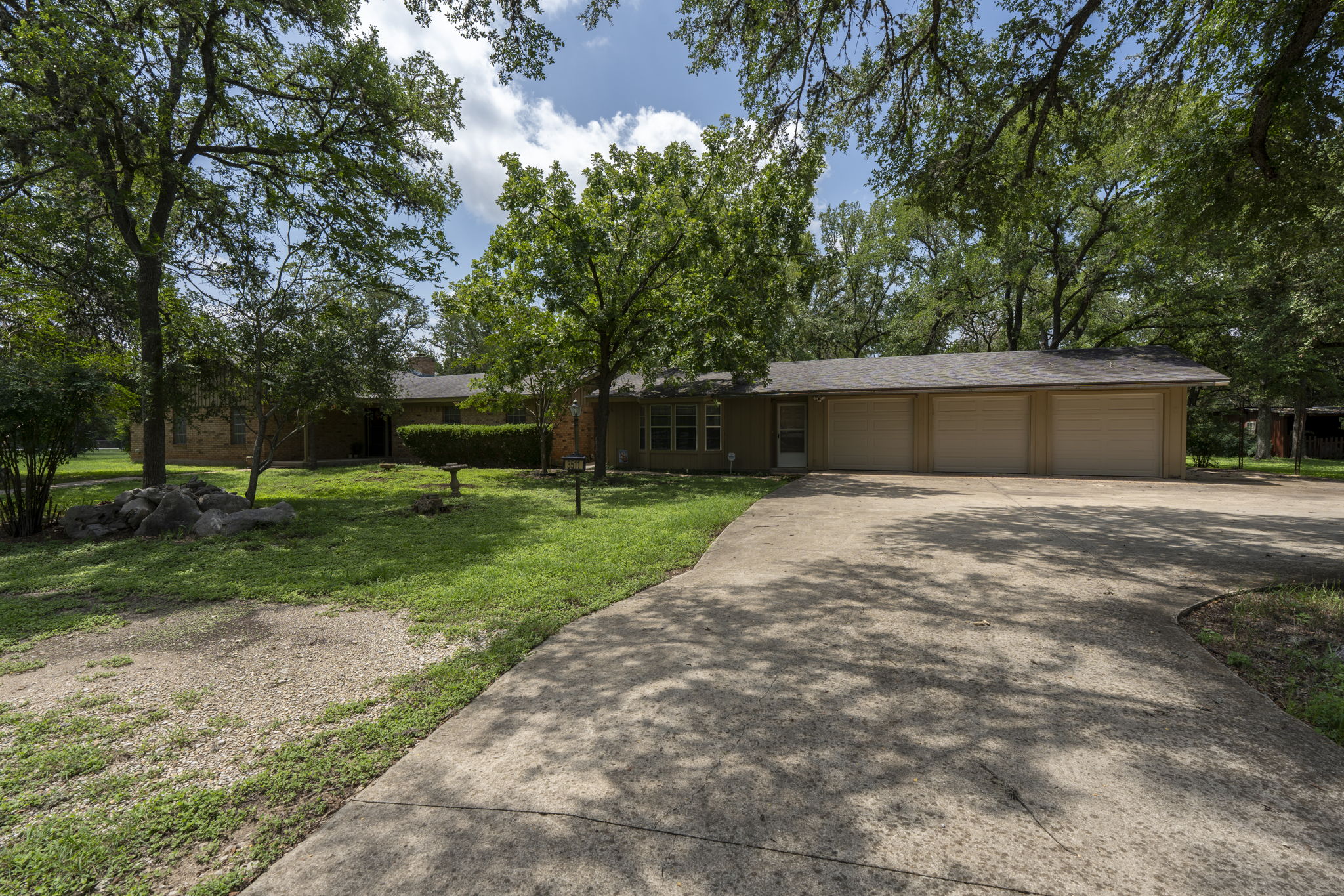 3511 Wyldwood Road Austin, TX 78739 - Photo 4 of 40 View of front of house with concrete driveway, a garage, a front lawn, and a shingled roof