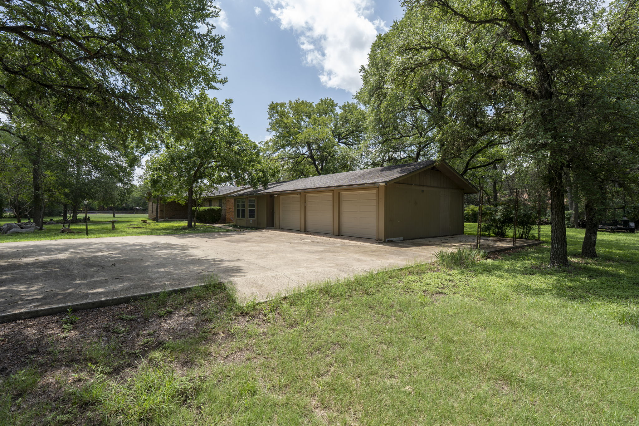 3511 Wyldwood Road Austin, TX 78739 - Photo 8 of 40 View of side of home with a lawn, driveway, a garage, and a shingled roof