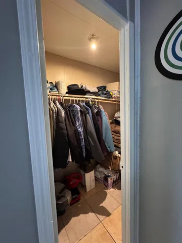 a view of walk in closet with clothes and shoes