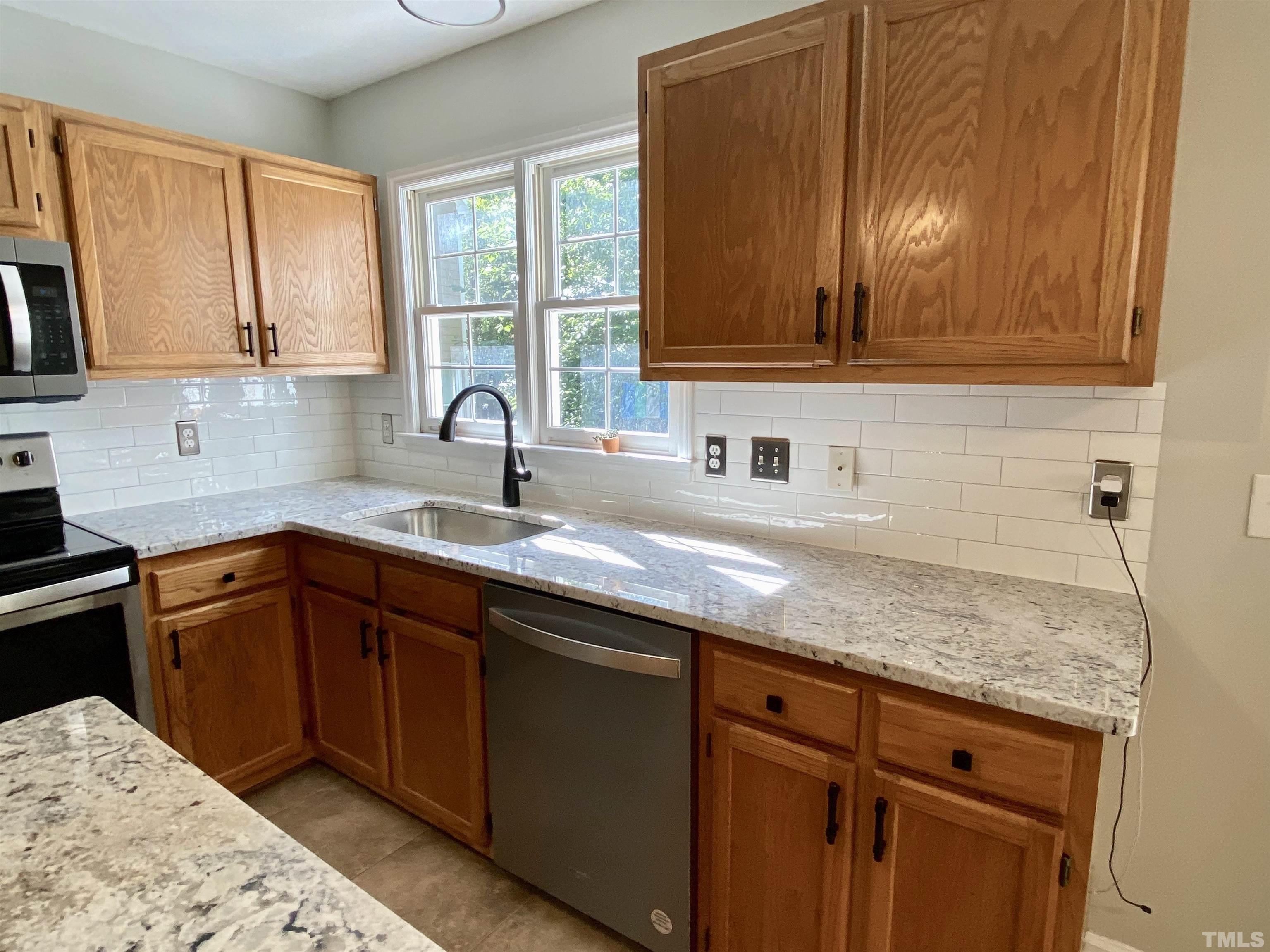 302 Bebington Drive Cary, NC 27513 - Photo 13 of 27 a kitchen with granite countertop a sink and cabinets