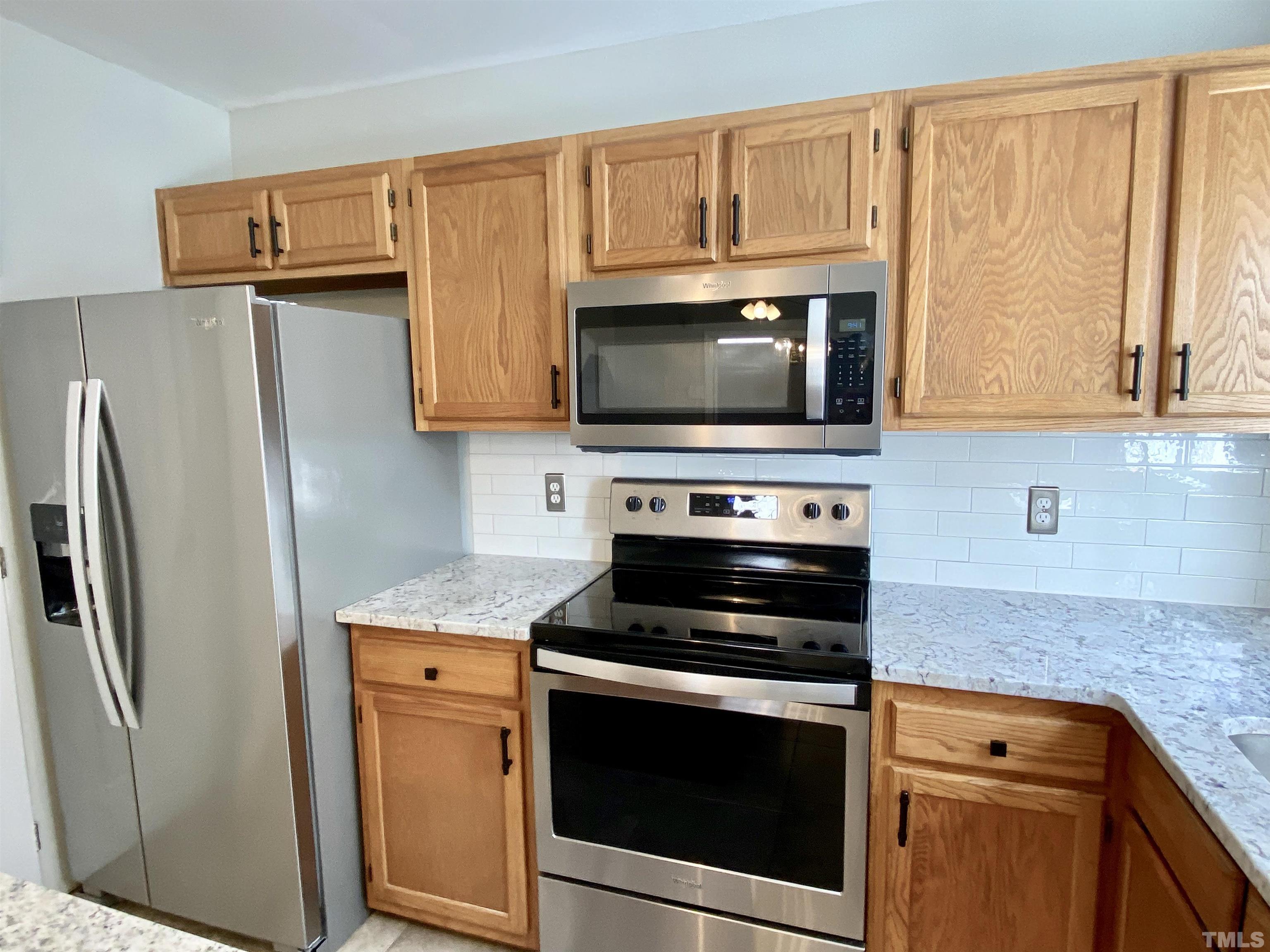 302 Bebington Drive Cary, NC 27513 - Photo 14 of 27 a kitchen with stainless steel appliances wooden cabinets and a stove top oven