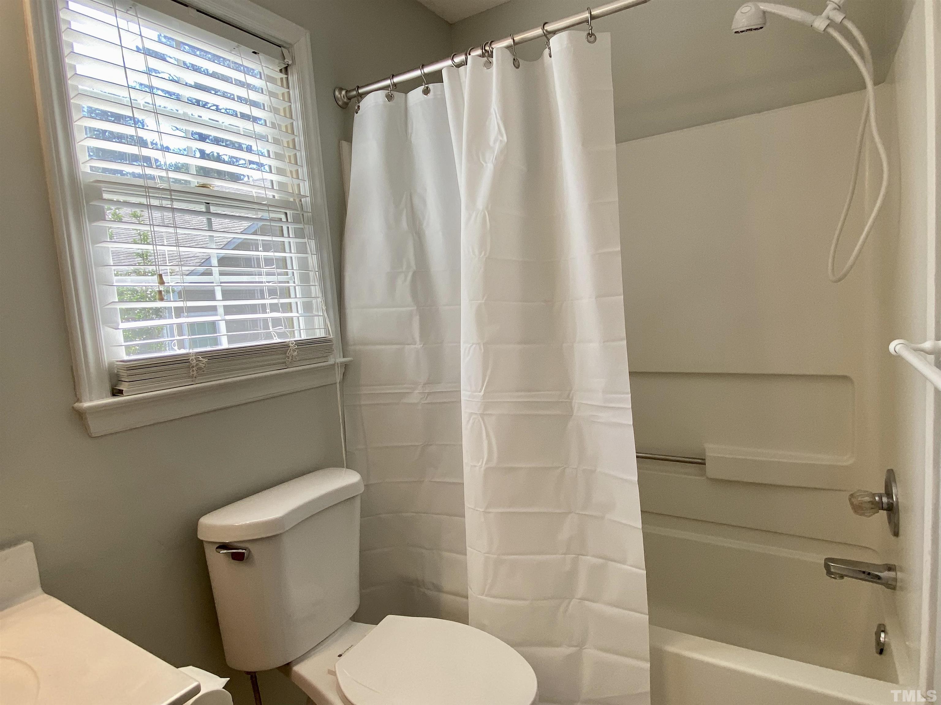 302 Bebington Drive Cary, NC 27513 - Photo 23 of 27 a bathroom with a toilet and a shower curtain