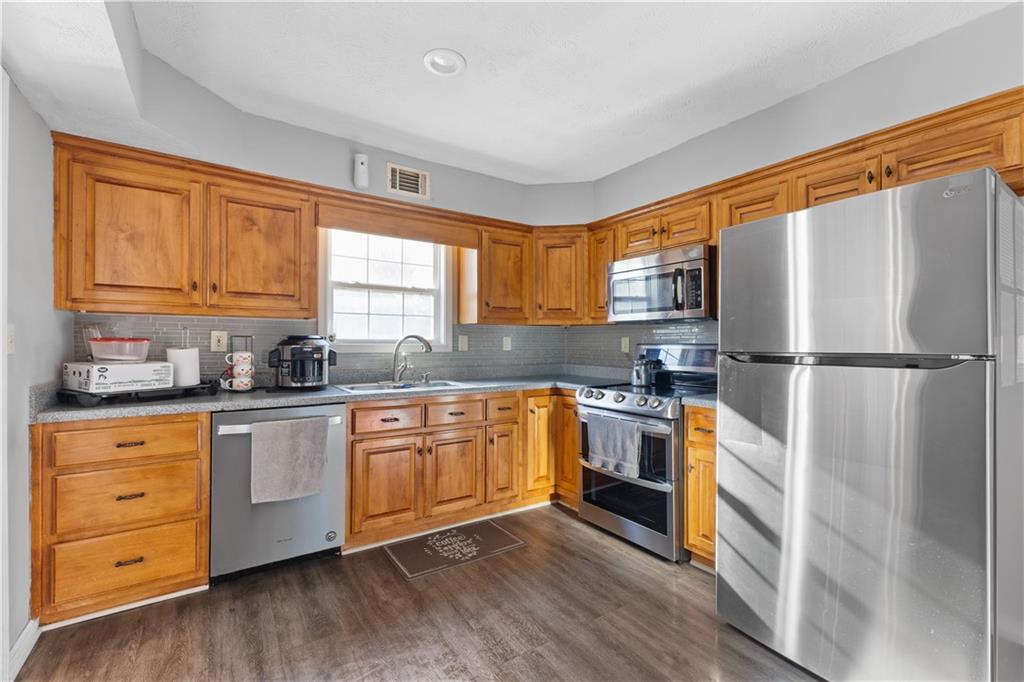 284 Oak Ridge Auburn, GA 30011 - Photo 2 of 13 a kitchen with granite countertop stainless steel appliances a refrigerator cabinets and wooden floor