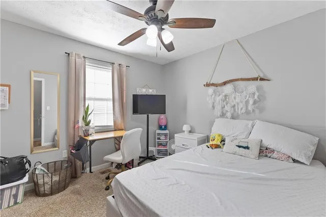 a bedroom with a bed a couch and a chandelier