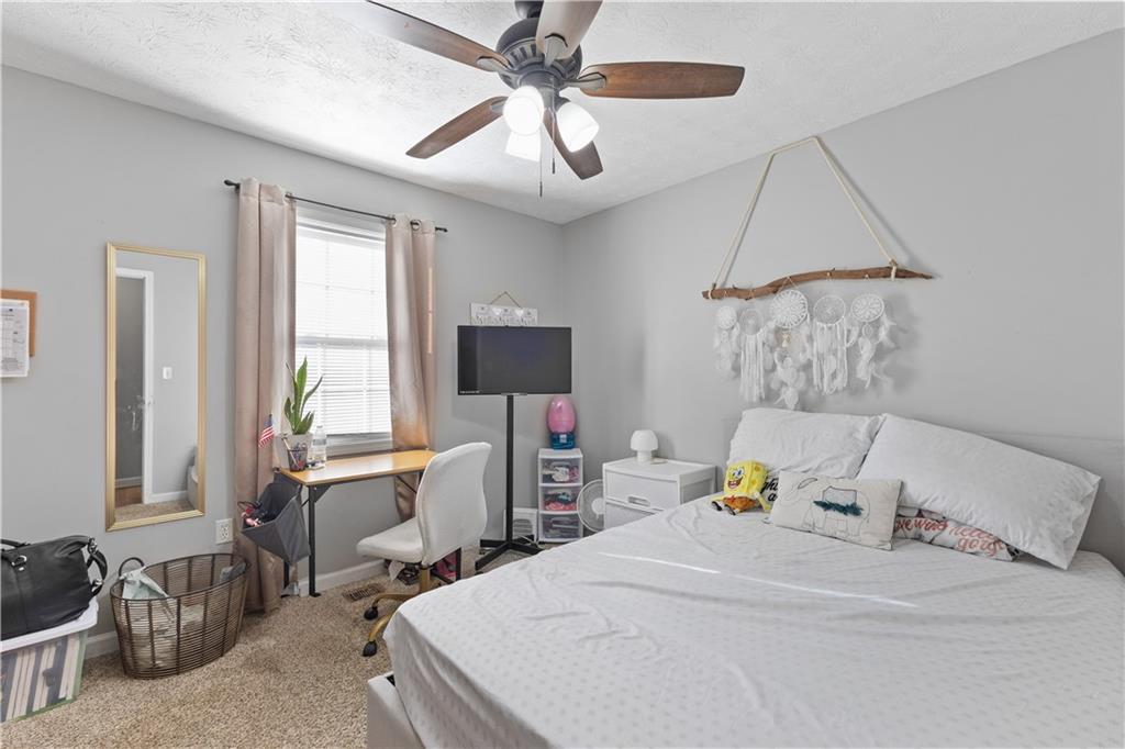 284 Oak Ridge Auburn, GA 30011 - Photo 7 of 13 a bedroom with a bed a couch and a chandelier