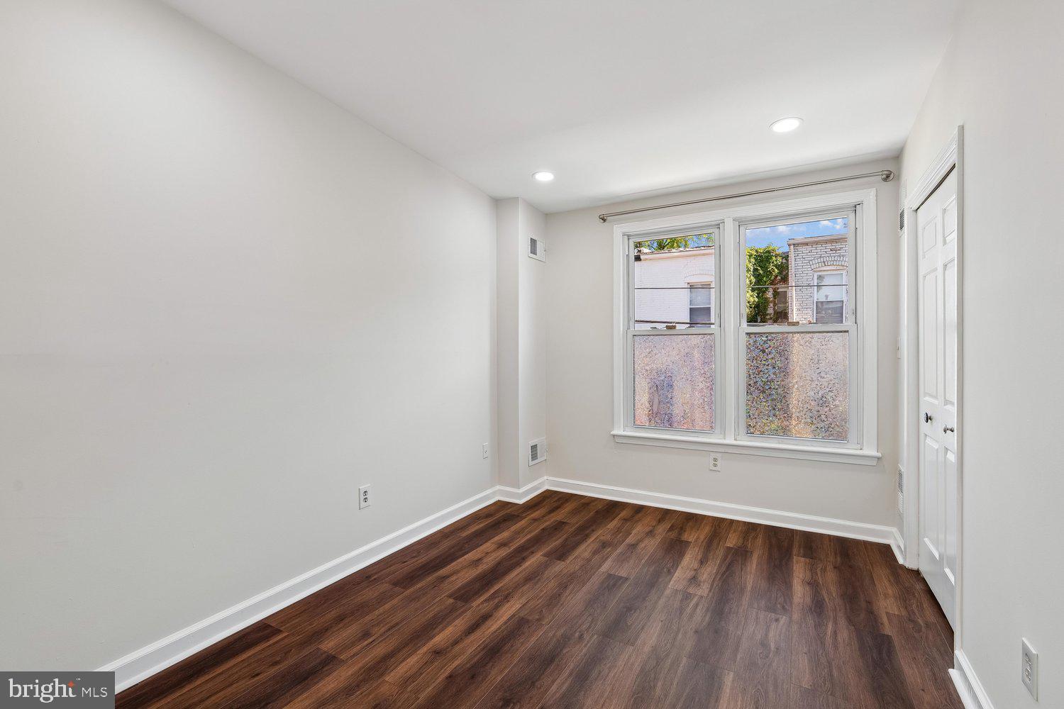1652 Kramer Street Northeast Washington, DC 20002 - Photo 19 of 26 a view of an empty room with wooden floor and a window