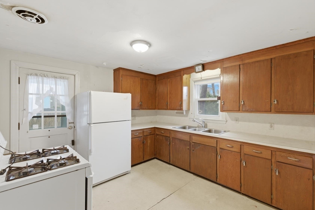 11 Clark Avenue Walpole, MA 02081 - Photo 6 of 25 a kitchen with sink a refrigerator and cabinets