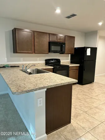 a kitchen with stainless steel appliances granite countertop a sink a microwave and wooden cabinets