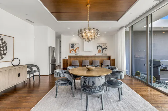 a view of a dining room with furniture a chandelier and wooden floor