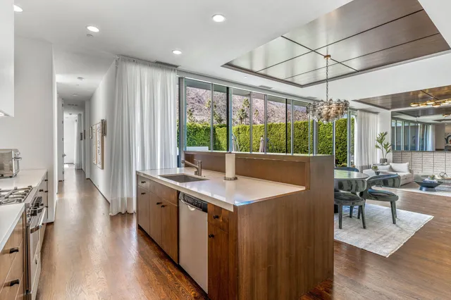 a view of a kitchen with kitchen island stainless steel appliances a sink and living room view