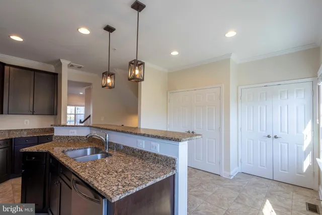 a kitchen with a sink a counter space and a chandelier