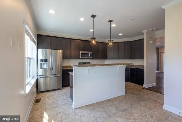 a view of a livingroom with furniture wooden floor fireplace and windows