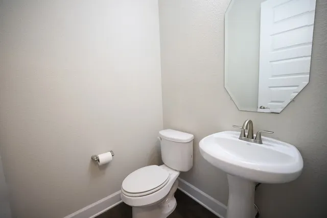a bathroom with a toilet sink and mirror