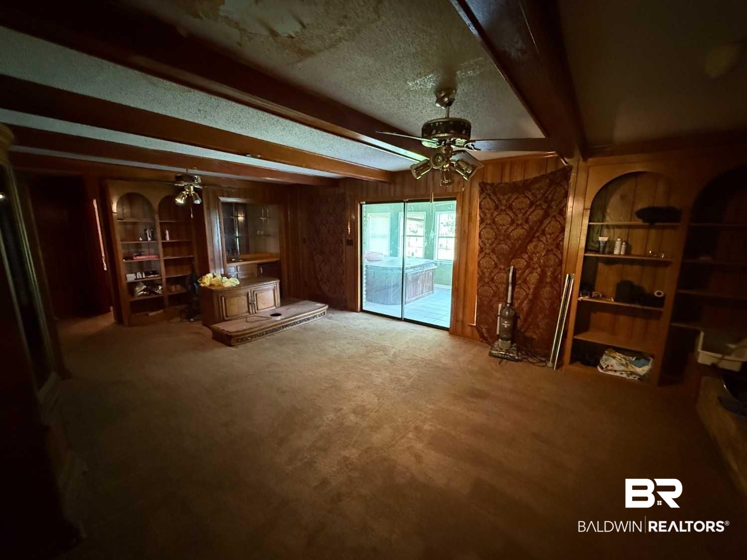 3721 Robertson Court Mobile, AL 36693 - Photo 14 of 22 Unfurnished living room with beamed ceiling, carpet floors, ceiling fan, a textured ceiling, and wooden walls