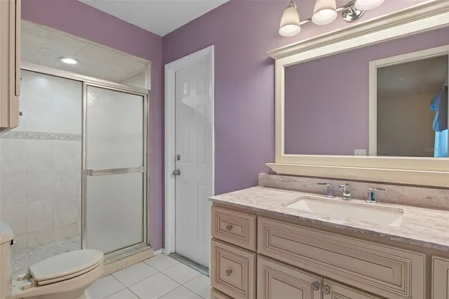 a bathroom with a granite countertop sink a toilet and shower