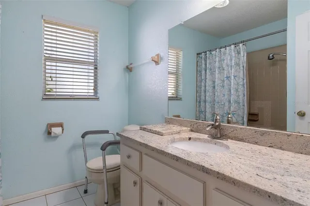 a bathroom with a granite countertop sink toilet and mirror