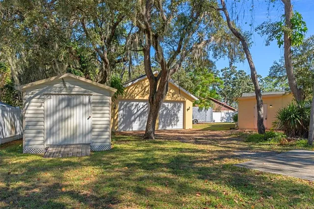 a view of a yard in front of a house with large trees