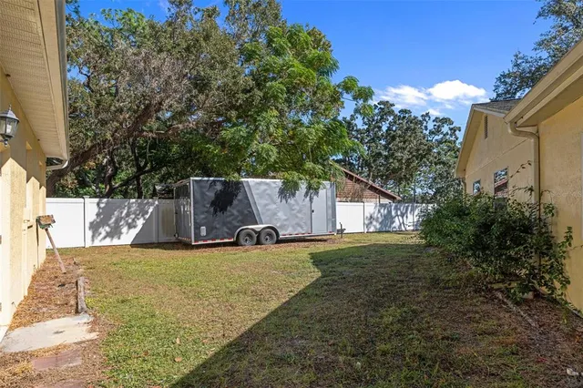 a view of a house with backyard and trees