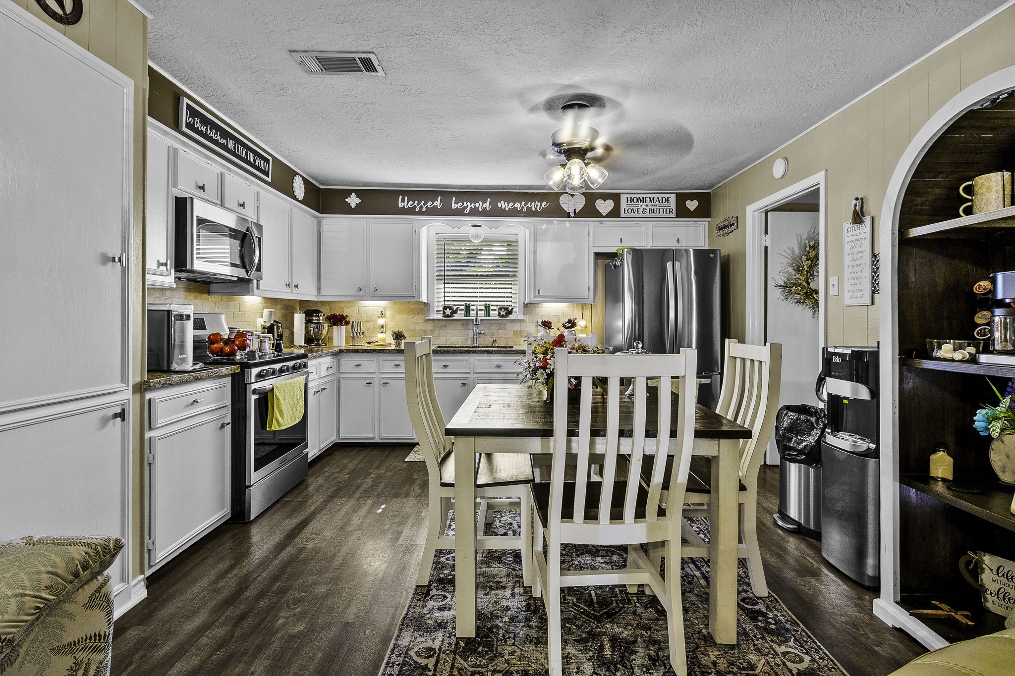 188 Huckleberry Road Onalaska, TX 77360 - Photo 10 of 49 a kitchen with stainless steel appliances kitchen island granite countertop a refrigerator a stove a sink dishwasher and white cabinets with wooden floor