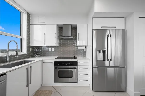 a kitchen with a refrigerator sink and cabinets