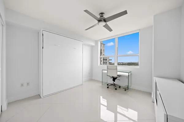 a living room with furniture a window and a ceiling fan