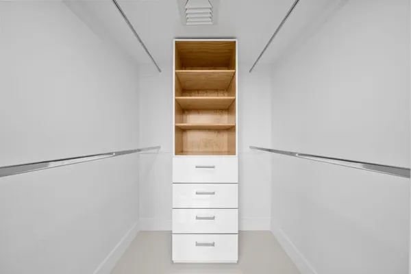 a view of walk in closet with empty racks