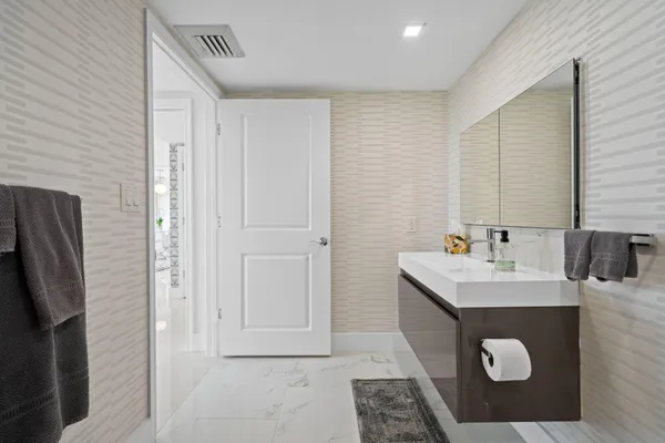 a bathroom with a sink a toilet and mirror